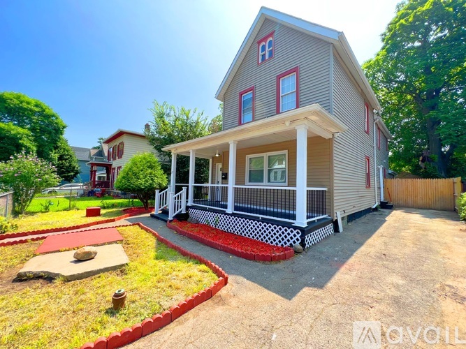 A house with a red front yard and a white porch.