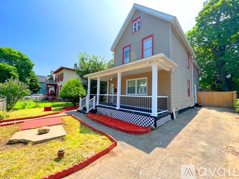 A house with a red front yard and a white porch.