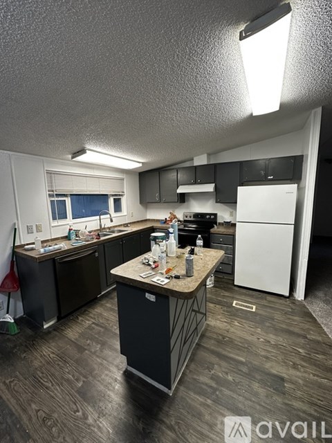 A kitchen with a white fridge and black cabinets.