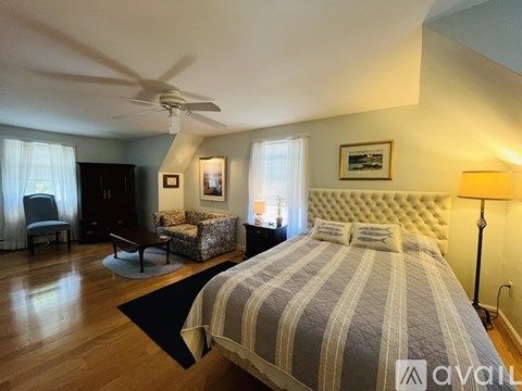 A bedroom with a large bed and a ceiling fan.