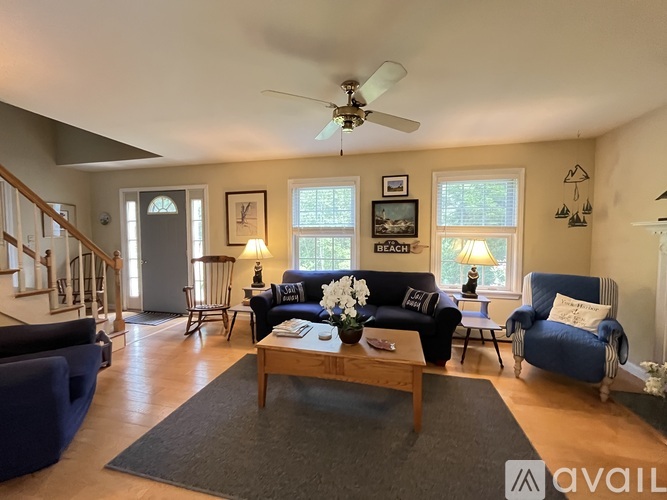 A living room with a blue couch and a wooden coffee table.