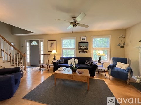 A living room with a blue couch and a wooden coffee table.