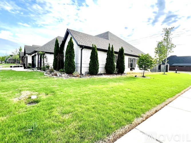 A house with a lawn and trees in front.