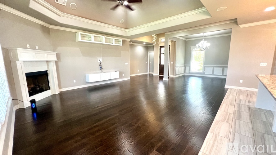 A spacious living room with a fireplace and hardwood floors.