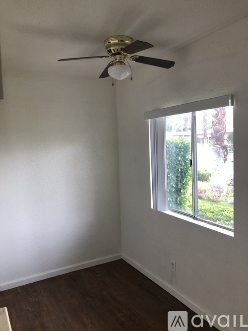 A room with a ceiling fan and a window.