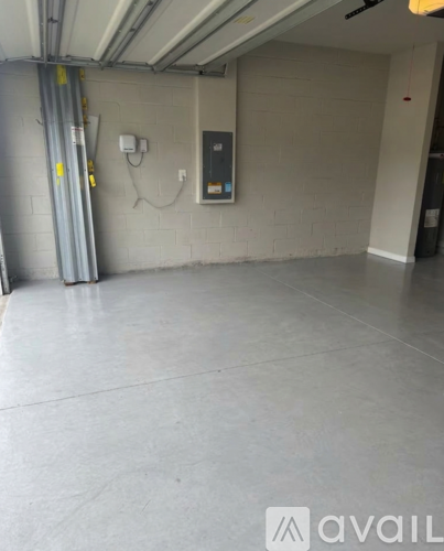 A spacious, empty parking garage with a concrete floor and white walls.