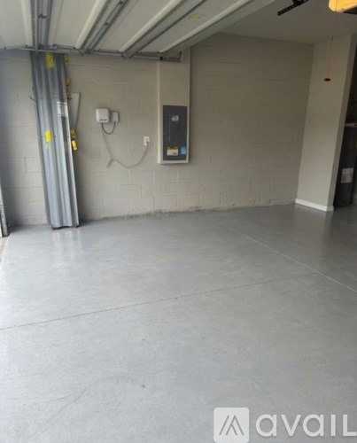 A spacious, empty parking garage with a concrete floor and white walls.