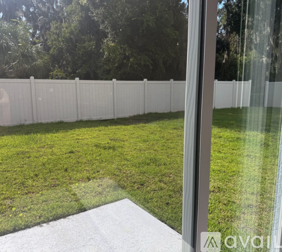 A white fence with green grass in front.