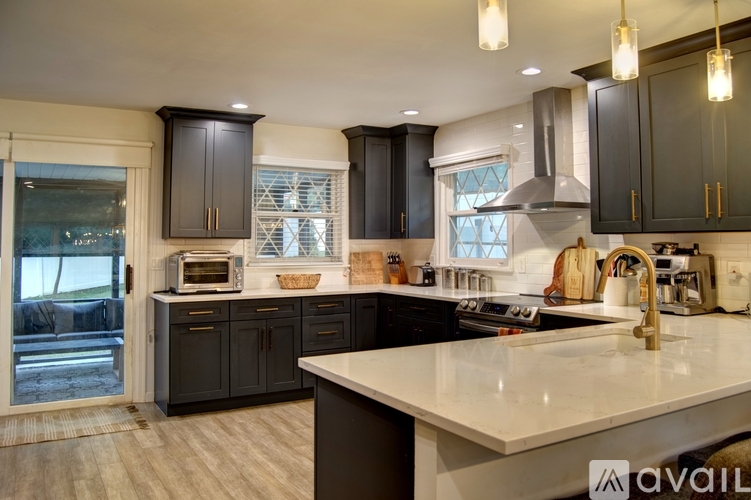 A kitchen with dark cabinets and a white countertop.