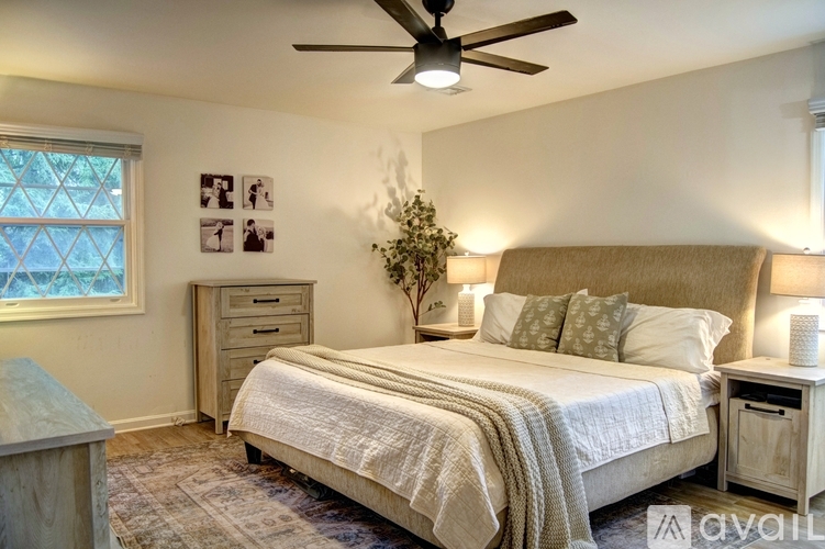 A bedroom with a bed, nightstand, and a ceiling fan.