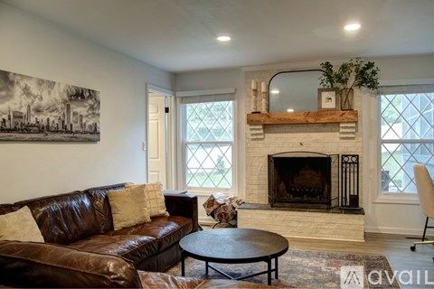 A living room with a fireplace and a painting on the wall.