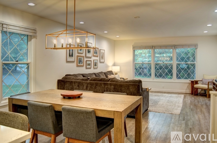 A modern dining room with a wooden table and chairs.