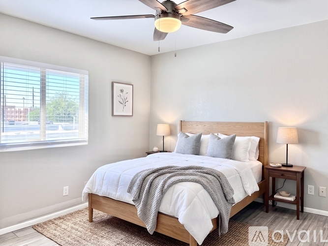 A bedroom with a bed, nightstand, and window.