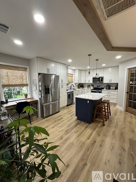 A kitchen with wooden floors and stainless steel appliances.