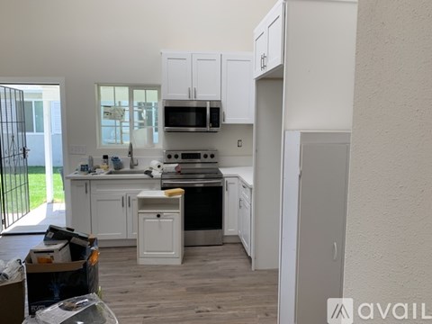 A kitchen with white cabinets and a black stove top oven.