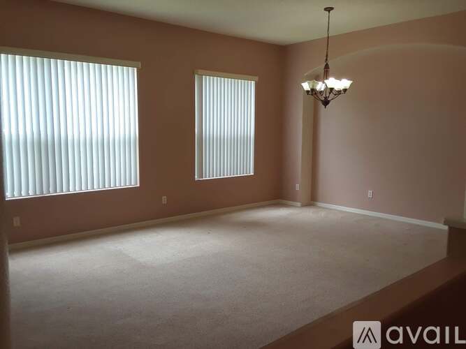 A bedroom with a red bedspread and a white wardrobe.