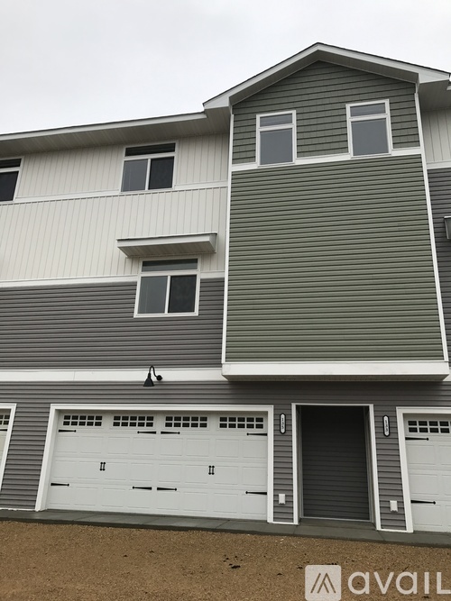 A two-story house with a garage on the lower level.