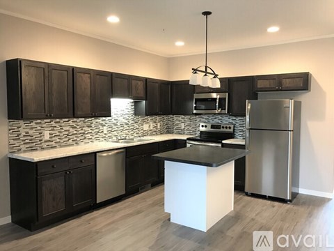 A kitchen with dark wood cabinets and a white island.
