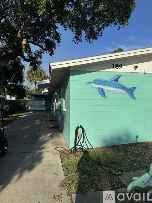 A blue dolphin mural is painted on the side of a building.