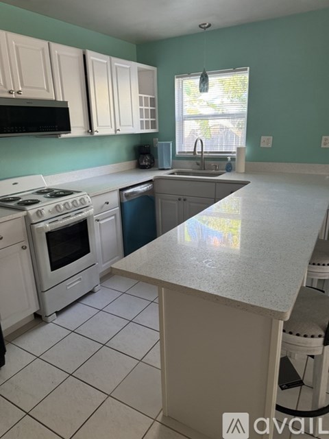 A kitchen with white appliances and cabinets.