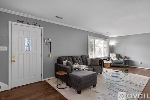 A living room with a grey couch and a white door.