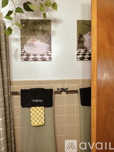 A bathroom with a towel hanging that says makeup on it.