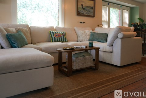 A living room with a white couch and a wooden coffee table.