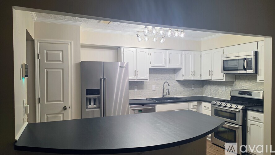 A kitchen with white cabinets and a wooden floor.
