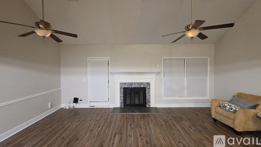 A living room with a fireplace and two ceiling fans.