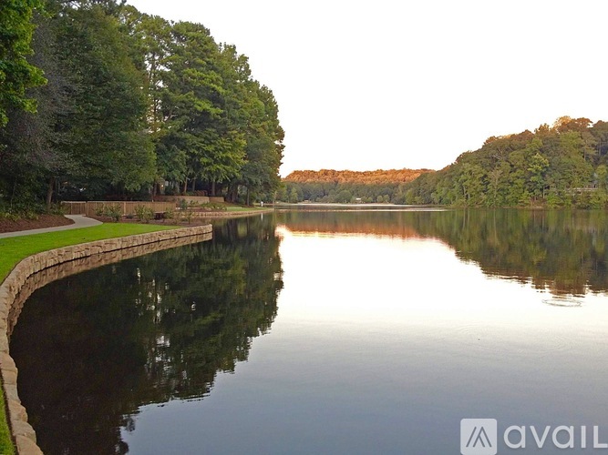 A serene lake surrounded by lush green trees.