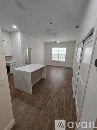 A kitchen with white cabinets and a marble island.