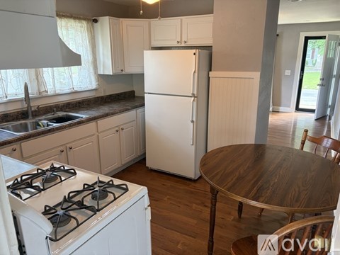 A kitchen with a white fridge, stove and cabinets.
