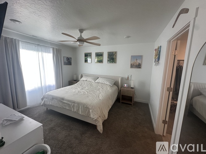 A bedroom with a large bed and a ceiling fan.