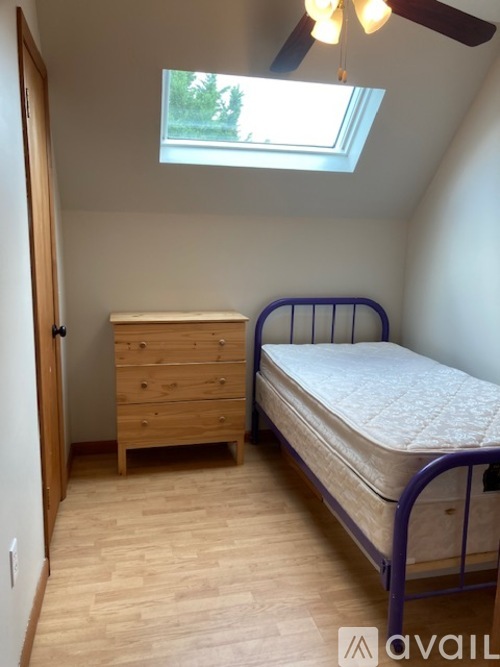 A bedroom with a bed, dresser and window.