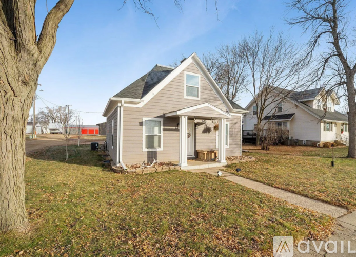 A house with a front yard and a tree in front of it.