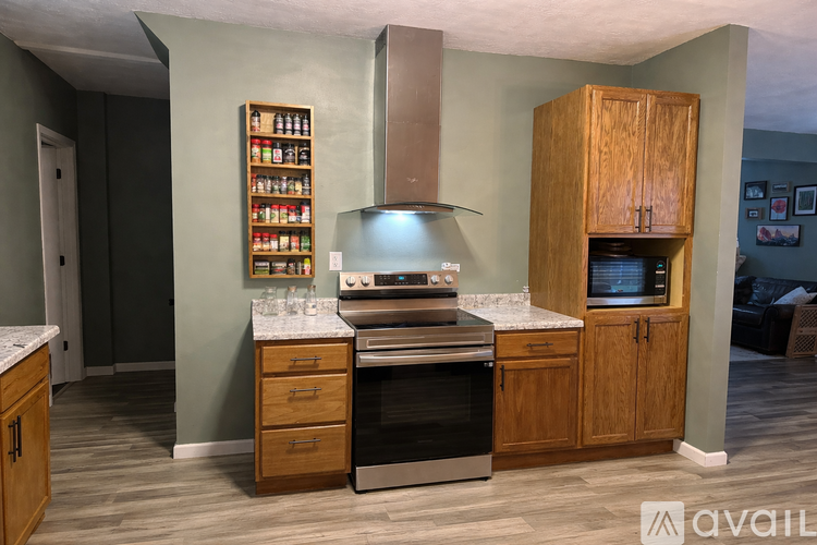 A kitchen with wooden cabinets and a stove top oven.
