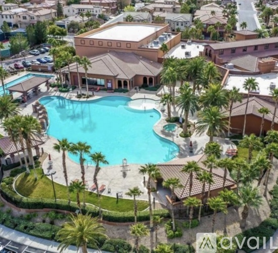 An aerial view of a resort with a swimming pool and palm trees.