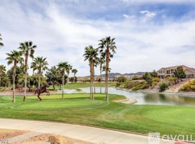 A horse is walking on a golf course with palm trees.