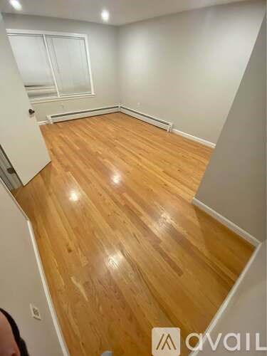 A room with wooden flooring and a window.