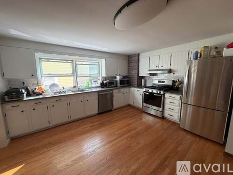 A kitchen with wooden floors and stainless steel appliances is available.