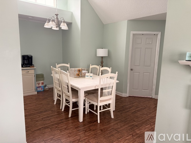 A dining room with a white table and chairs.