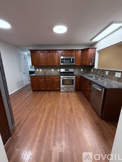 A kitchen with wooden cabinets and a stainless steel dishwasher.