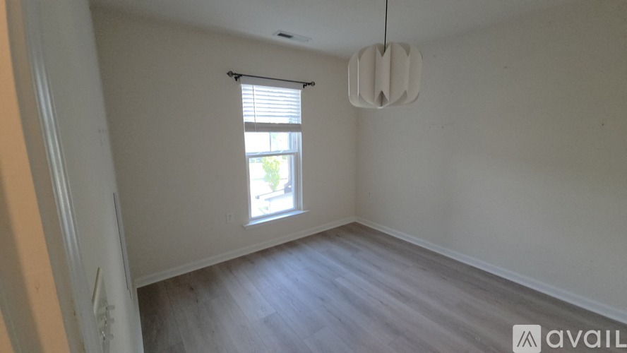 A room with a window and wooden flooring.