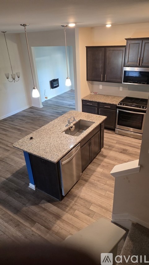 A kitchen with a granite countertop and stainless steel appliances.