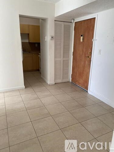 A room with a wooden door and a tiled floor.