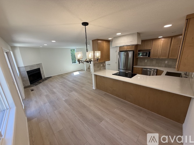 A modern kitchen with wooden cabinets and a central island.