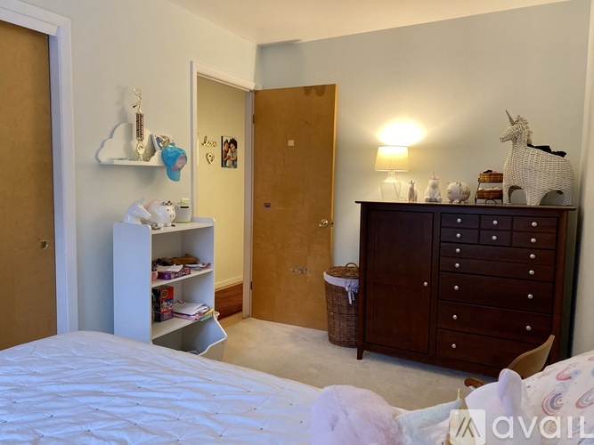 A bedroom with a white bed and a brown wardrobe.