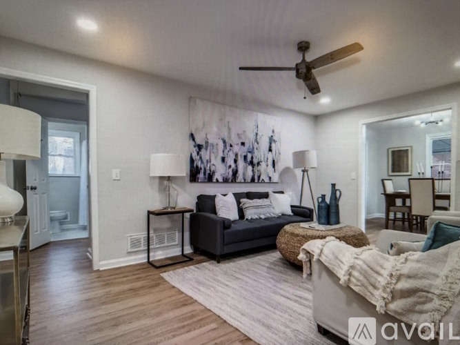 A living room with a couch, a rug, and a painting on the wall.
