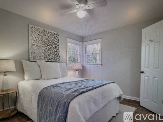 A bedroom with a bed, a ceiling fan, and a window.