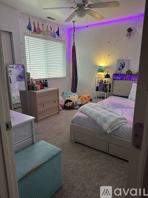 A bedroom with a bed, dresser, and a ceiling fan.